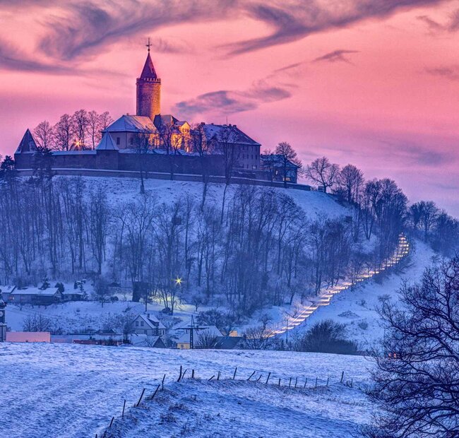 Winterliche Leuchtenburg im Farbenspiel der Dämmerung