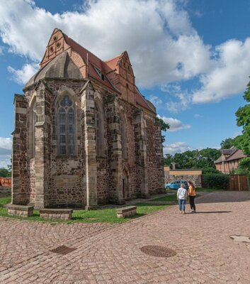 Außenansicht der Templerkapelle in Mücheln bei Wettin mit zwei Personen