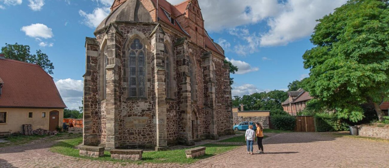 Außenansicht der Templerkapelle in Mücheln bei Wettin mit zwei Personen