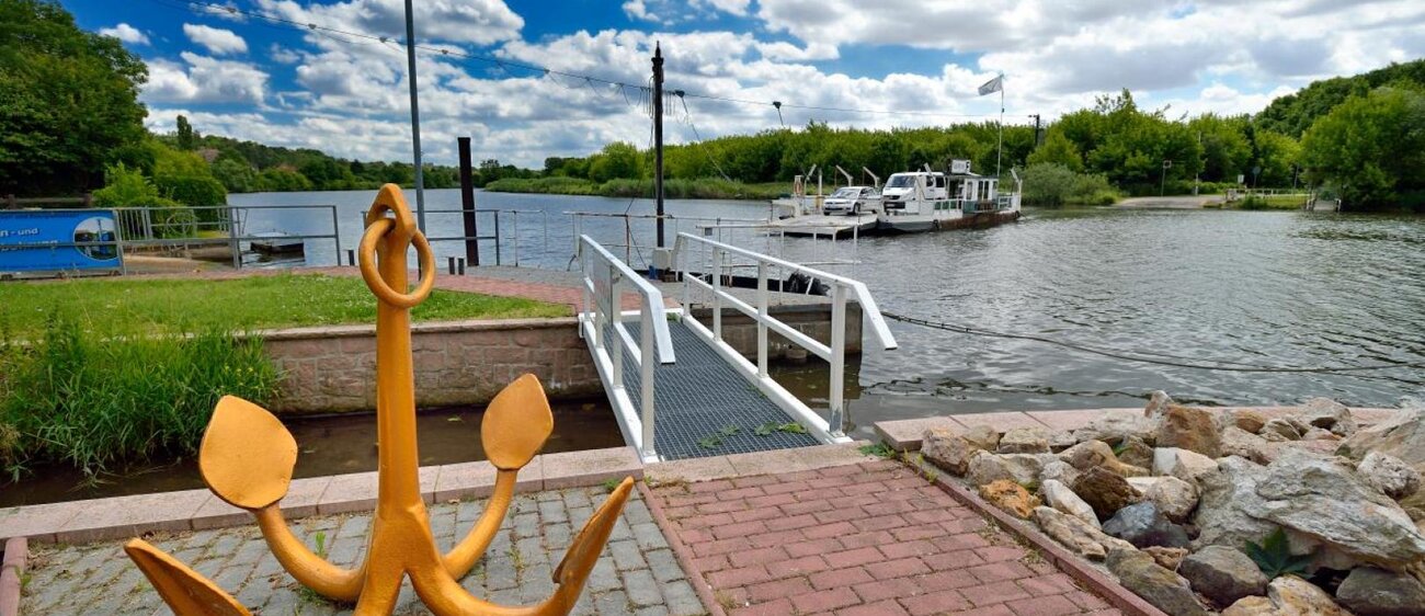 Blick von der Anlegestelle mit Anker, Saale und Fähre beim Übersetzen